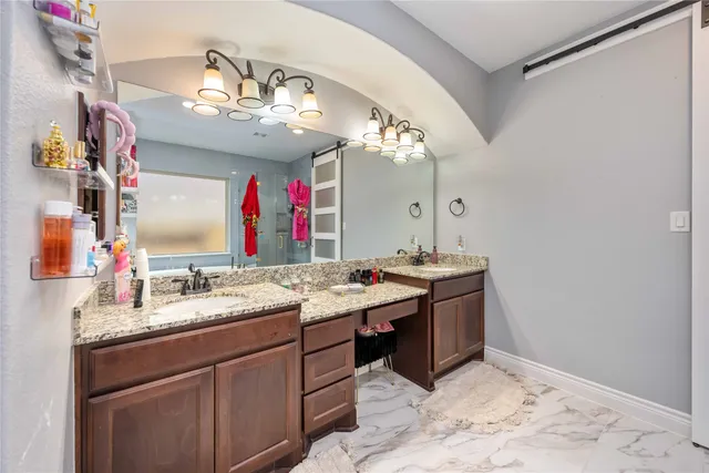 a spacious bathroom with a sink vanity granite and a mirror
