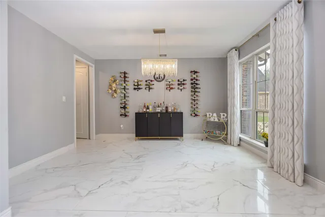 a view of a big room with windows and chandelier fan