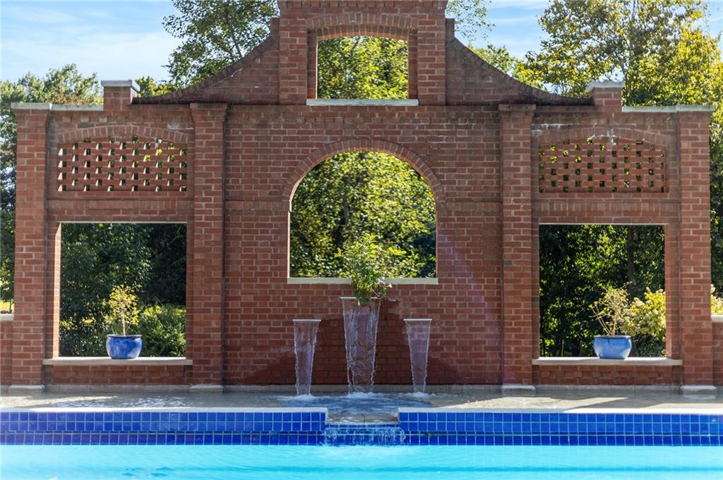 898 Persimmon Road Sewickley, PA 15143 - Photo 3 of 50 Anchoring the outdoor experience is a spectacular pool terrace, flanked by an architectural brick backdrop with arched openings that mirror the home’s own classical shapes.