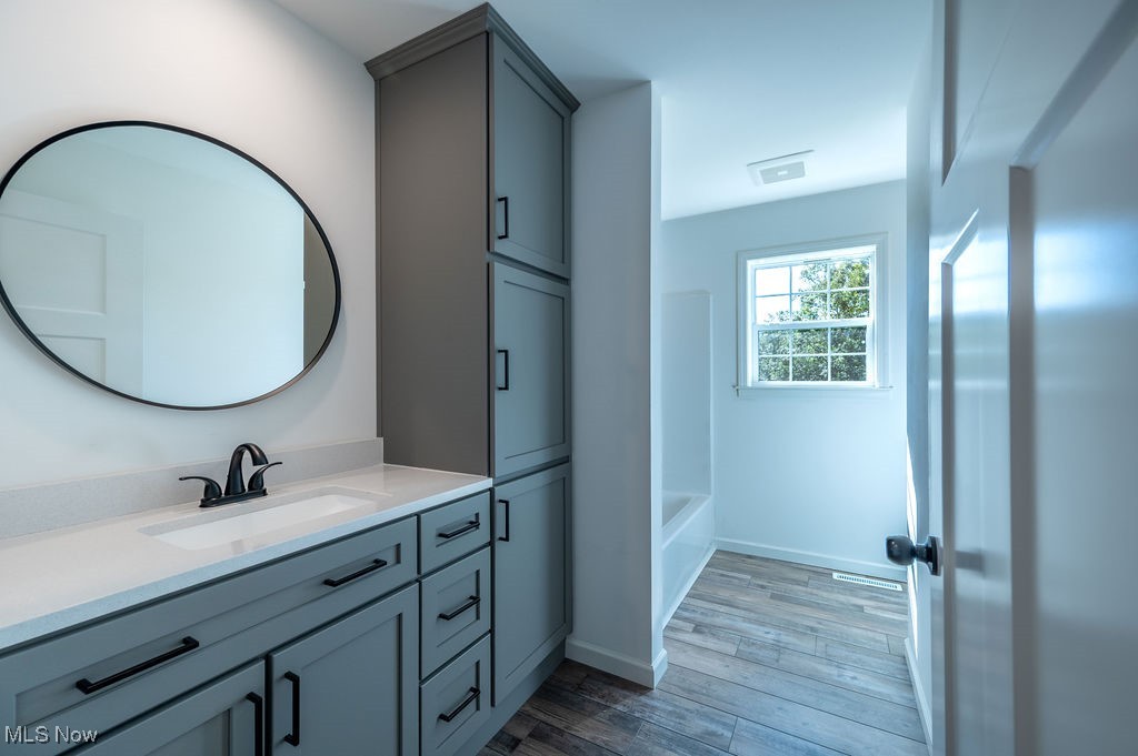 7343 Lost Pavement Road Belleville, WV 26133 - Photo 23 of 49 Bathroom featuring vanity, light wood-style floors, and tub / shower combination