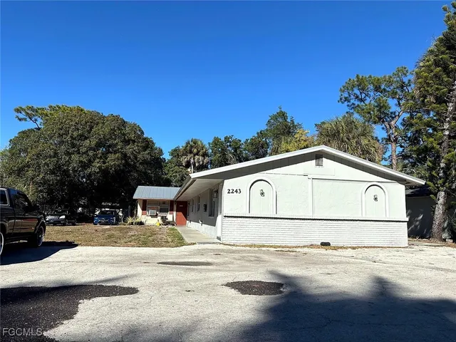 a view of a white house with a yard