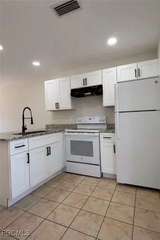 a kitchen with a stove sink and refrigerator