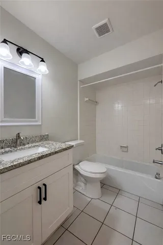 a bathroom with a granite countertop sink mirror vanity and toilet