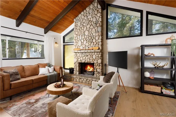 a living room with furniture a fireplace and a floor to ceiling window