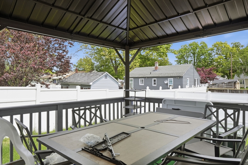 19 Annies Way Springfield, MA 01119 - Photo 35 of 40 a view of a patio with table and chairs under an umbrella with a small yard