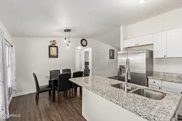 a kitchen with granite countertop a refrigerator a table and chairs