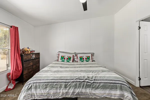 a bedroom with a bed and a painting on the wall