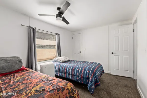 a bedroom with a bed a chandelier and a window