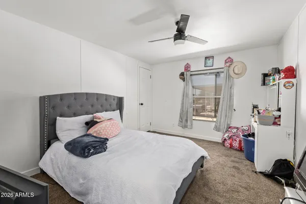 a bedroom with a bed a chandelier and dresser