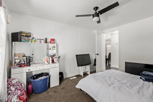 a bedroom with a bed a flat screen tv and dresser