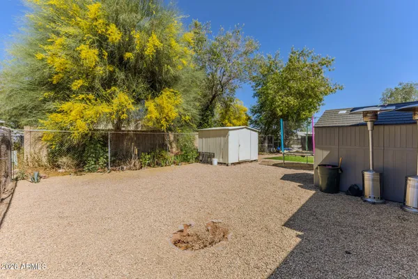 a backyard of a house with a basket ball court and a fire pit