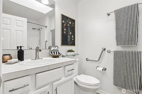 a bathroom with a toilet a sink and mirror