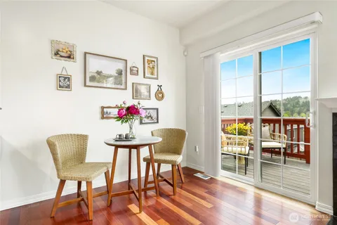 a dining room with furniture potted plants and wooden floor