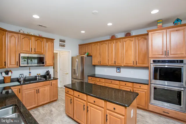a kitchen with stainless steel appliances a stove sink microwave and cabinets