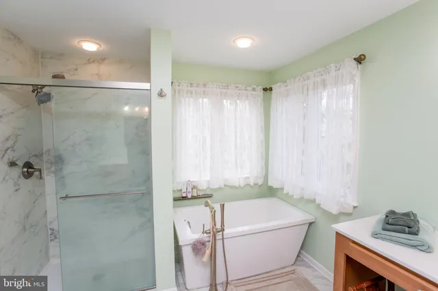 a bathroom with a tub shower and sink