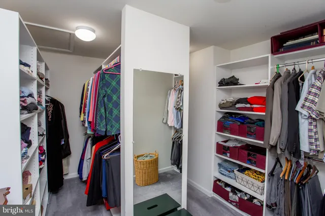 a view of walk in closet with clothes and shoes