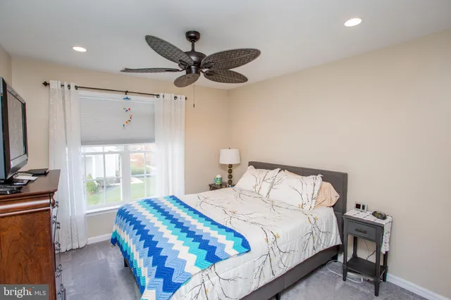 a bedroom with a bed and a flat tv screen on dresser