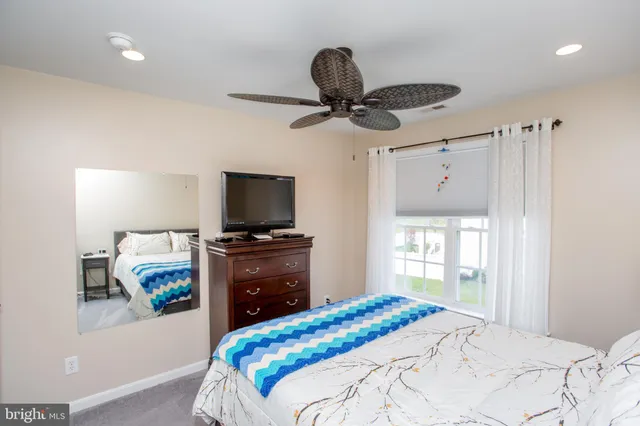 a bedroom with a bed and a flat tv screen on a dresser
