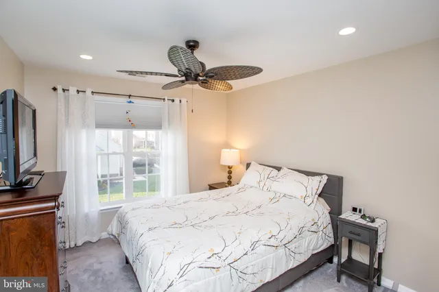 a bedroom with a bed flat screen tv and a window