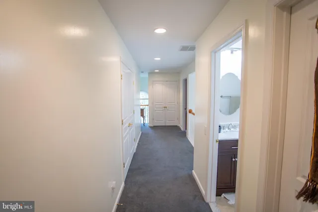 a view of a hallway with a livingroom and a bathroom
