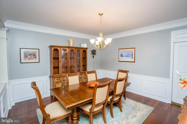 a dining room with furniture a chandelier and wooden floor