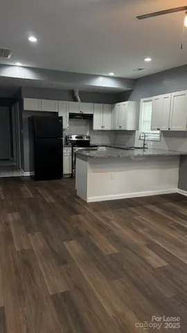 a kitchen with stainless steel appliances kitchen island granite countertop a stove a sink and a microwave