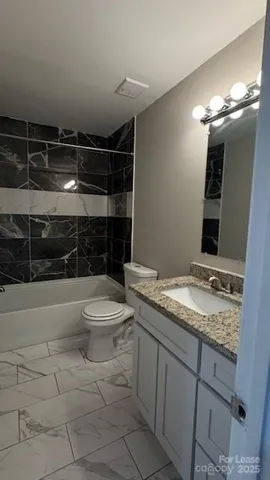 a bathroom with a granite countertop sink toilet and shower