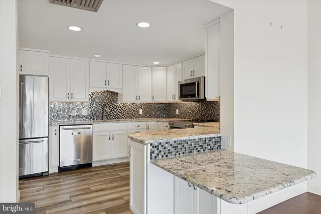 a kitchen with kitchen island granite countertop a sink stove and refrigerator