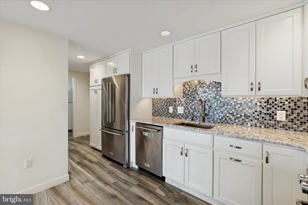 a kitchen with granite countertop white cabinets and stainless steel appliances