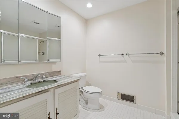 a bathroom with a granite countertop sink a toilet and a mirror