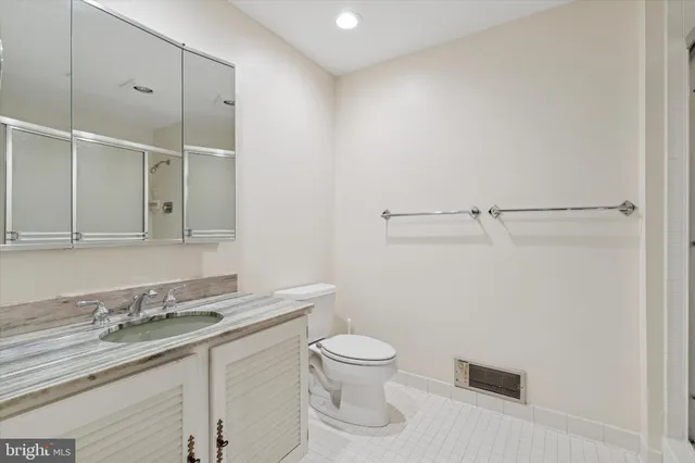 a bathroom with a granite countertop sink a toilet and a mirror
