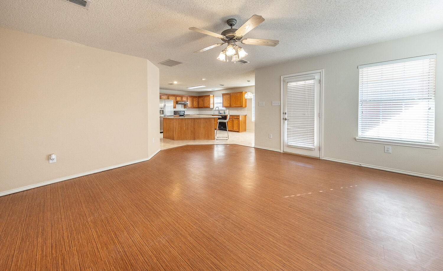 5815 89th Street Lubbock, TX 79424 - Photo 12 of 31 a view of an empty room with a window and wooden floor