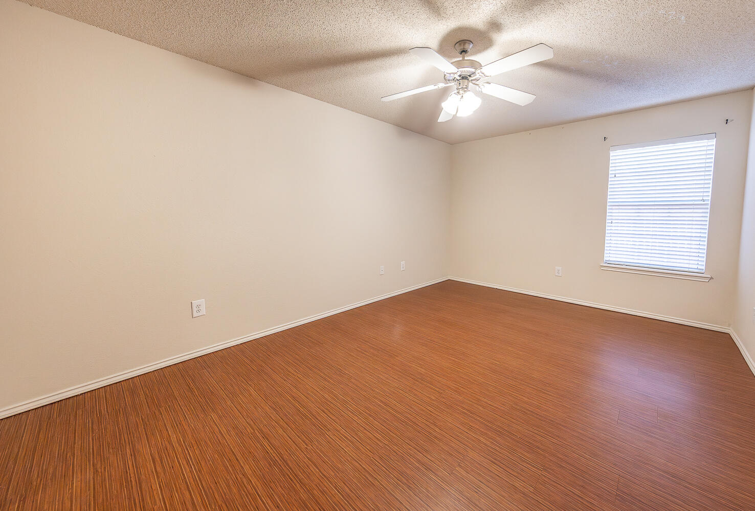 5815 89th Street Lubbock, TX 79424 - Photo 21 of 31 an empty room with a chandelier fan and windows