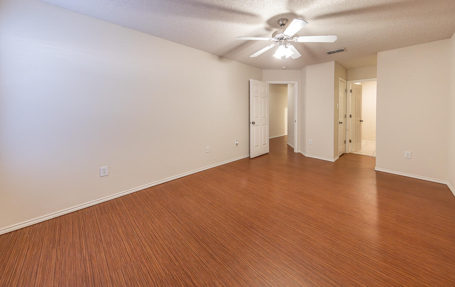 5815 89th Street Lubbock, TX 79424 - Photo 22 of 31 an empty room with a chandelier fan and wooden floor