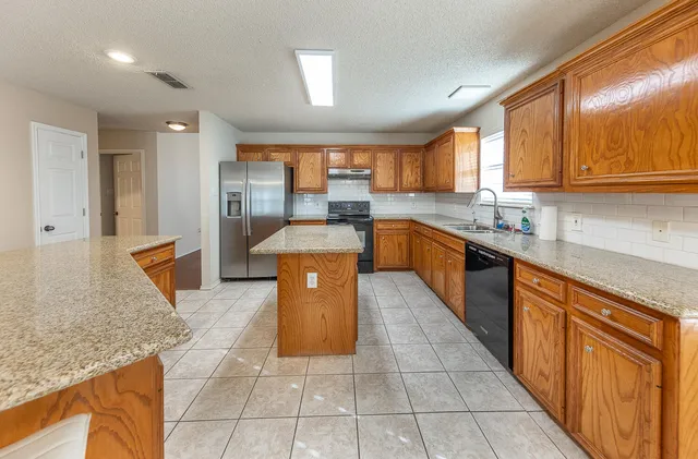 a kitchen with stainless steel appliances granite countertop a sink counter space cabinets and a large window