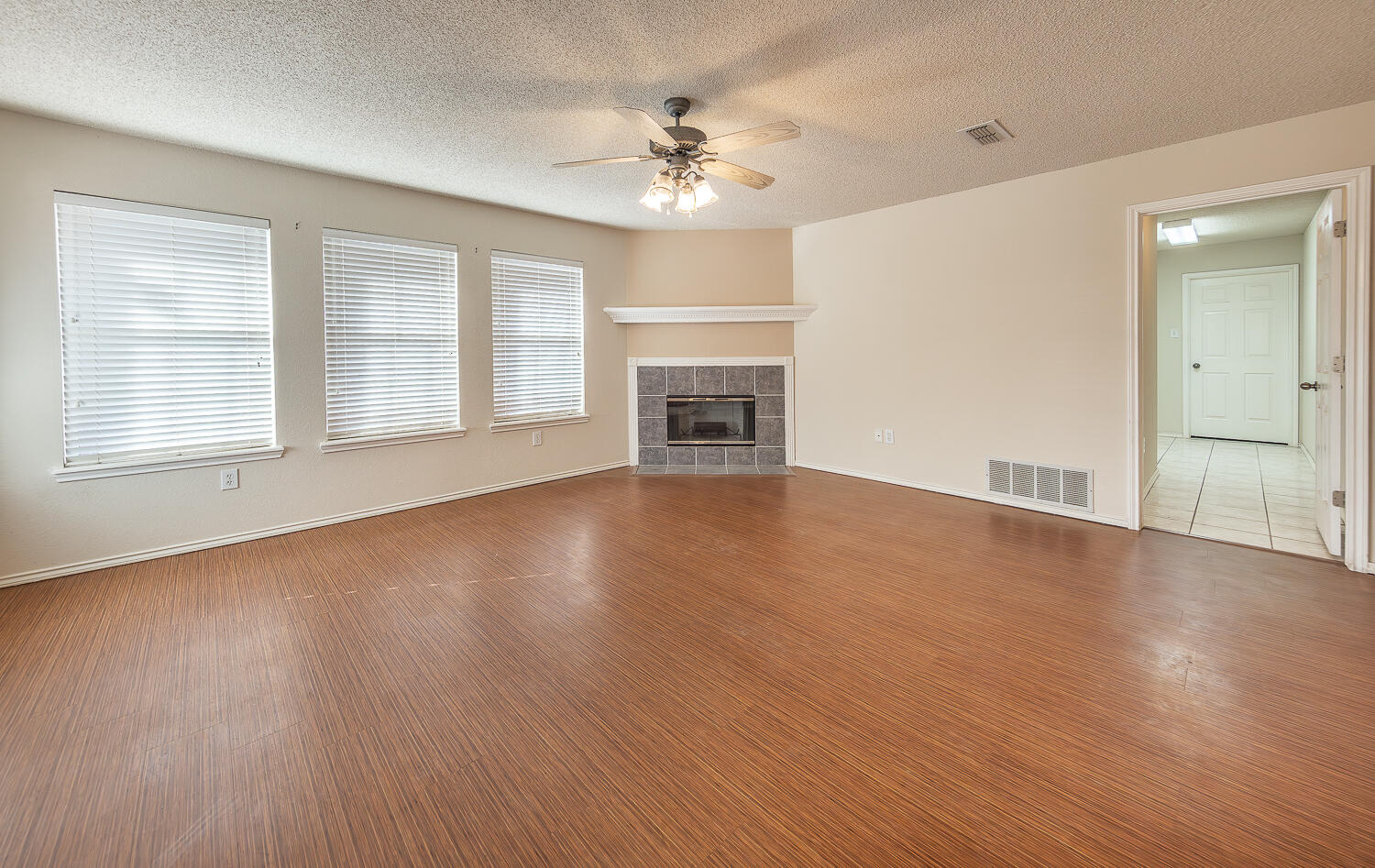 5815 89th Street Lubbock, TX 79424 - Photo 10 of 31 an empty room with wooden floor fireplace and windows
