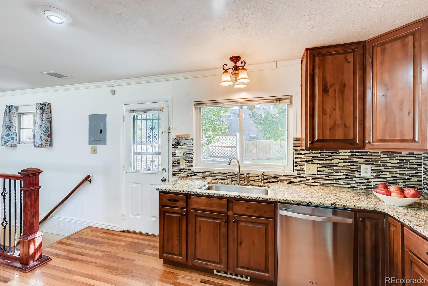 2621 Paseo Road Colorado Springs, CO 80907 - Photo 11 of 27 a kitchen with stainless steel appliances granite countertop a sink a stove cabinets and wooden floor