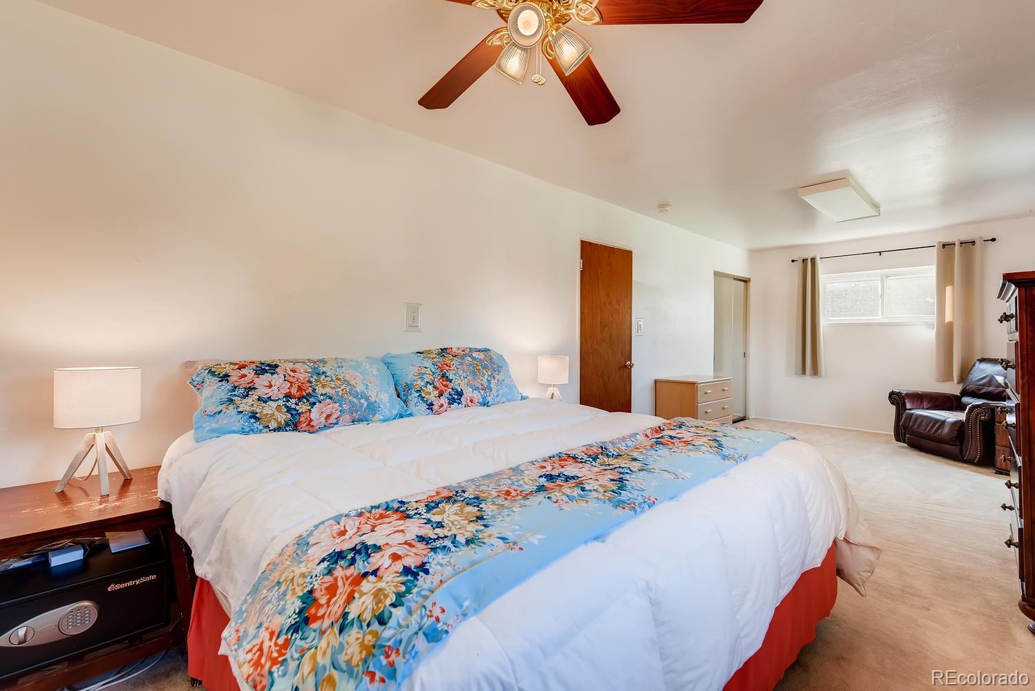 2621 Paseo Road Colorado Springs, CO 80907 - Photo 13 of 27 a bedroom with a bed and a chandelier