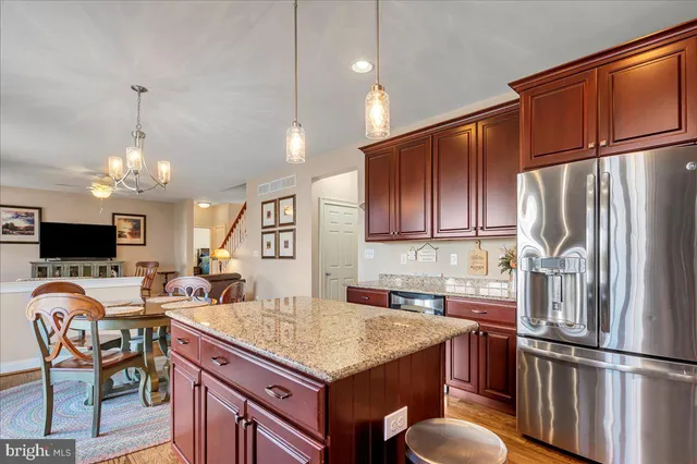 a kitchen with granite countertop a refrigerator stove top oven and sink