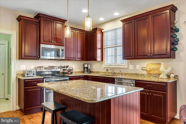a kitchen with granite countertop a sink stove and cabinets