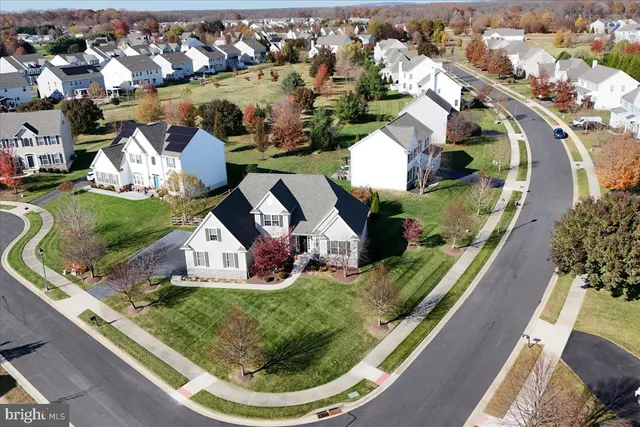 a aerial view of a house with swimming pool lawn chairs and a barbeque