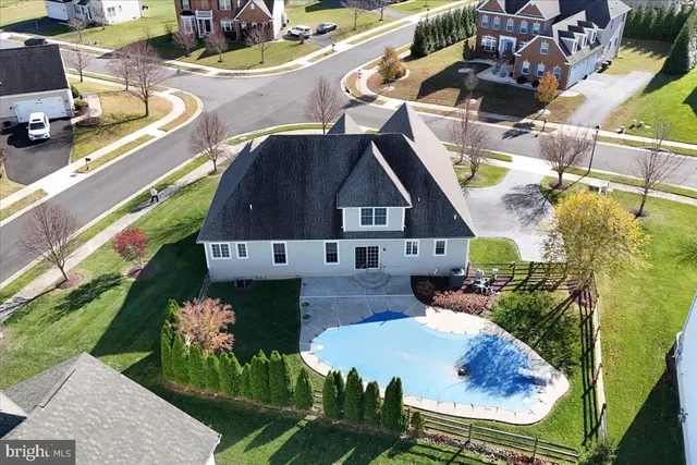 an aerial view of residential house with outdoor space and a swimming pool