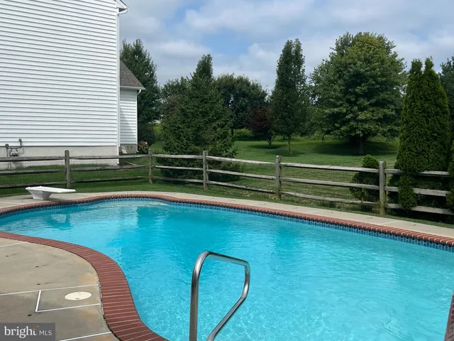 a front view of a house with garden and sitting area