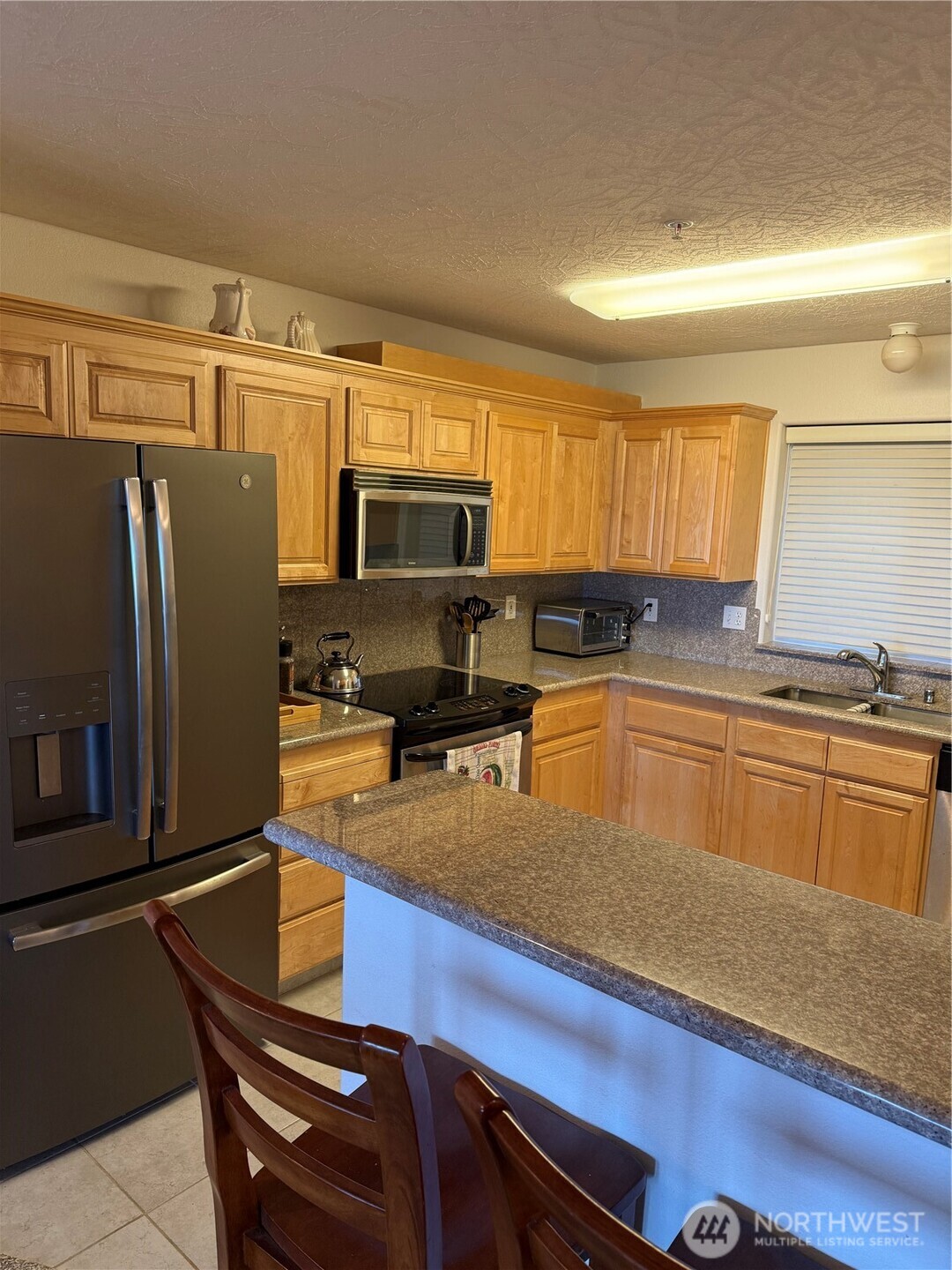2815 Willows Road, Unit 116 Seaview, WA 98644 - Photo 11 of 30 a kitchen with stainless steel appliances a refrigerator sink and microwave