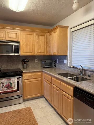 a kitchen with stainless steel appliances granite countertop a sink stove and microwave