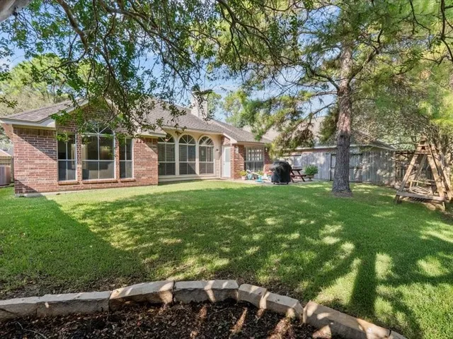 an aerial view of residential houses with outdoor space and trees