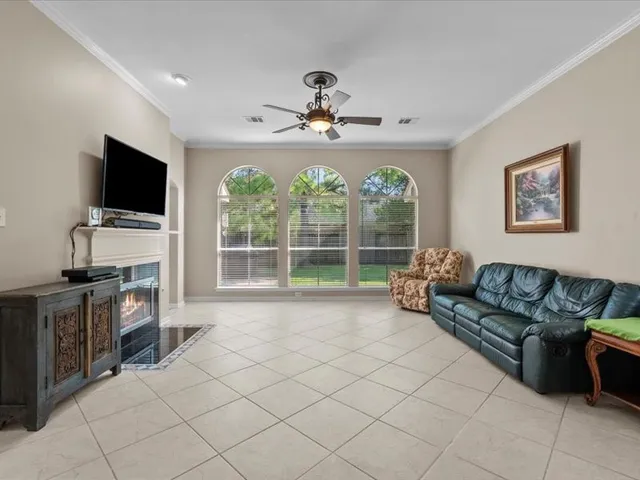 a living room with furniture a flat screen tv and a large window