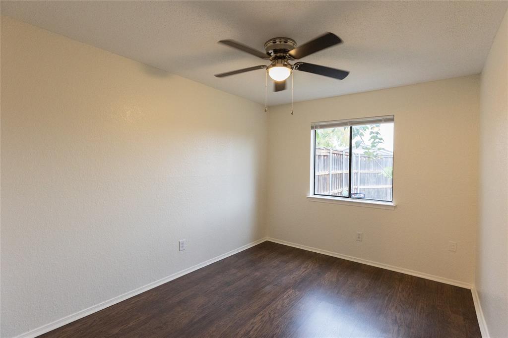 1031 East Peters Colony Road Carrollton, TX 75007 - Photo 12 of 21 an empty room with wooden floor fan and windows