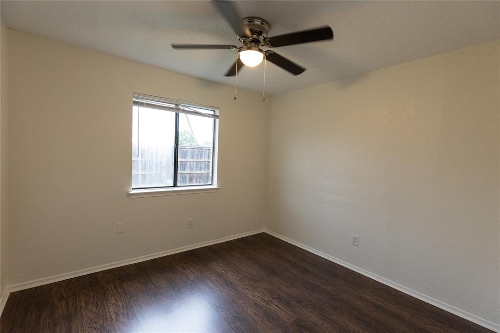 1031 East Peters Colony Road Carrollton, TX 75007 - Photo 14 of 21 an empty room with wooden floor ceiling fan and windows