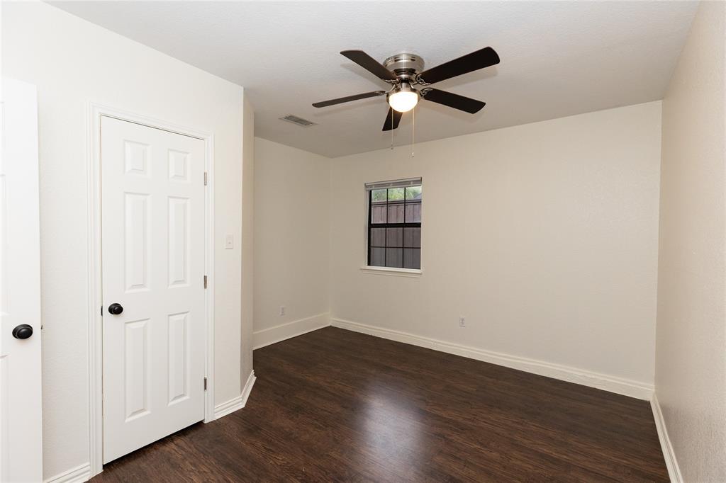 1031 East Peters Colony Road Carrollton, TX 75007 - Photo 16 of 21 an empty room with wooden floor ceiling fan and windows